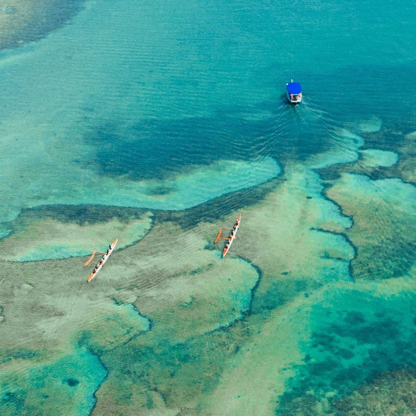 Vista aérea de duas canoas havaianas sobre o recife de corais