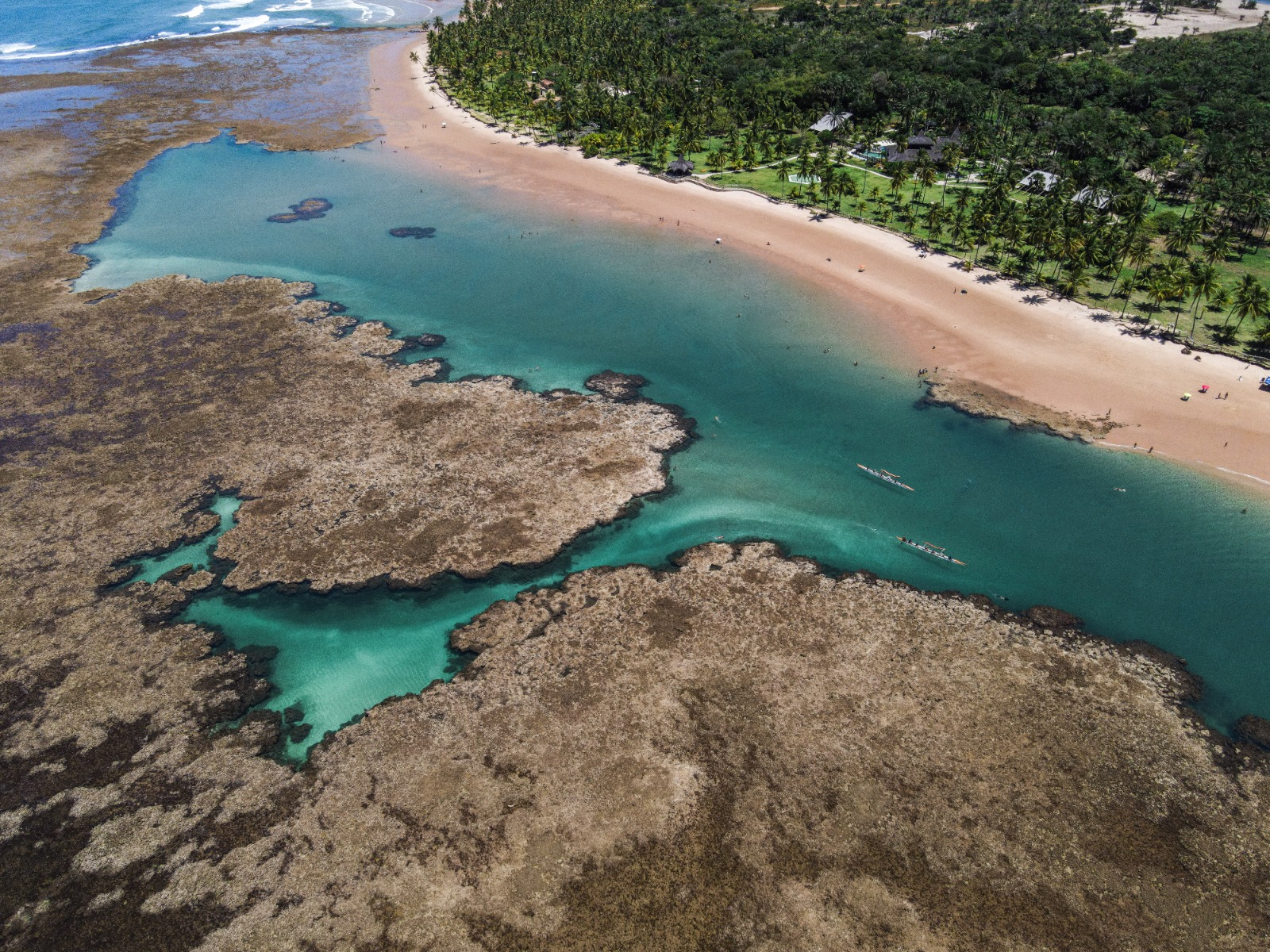 Vista aérea da praia com recifes e canoas havaianas